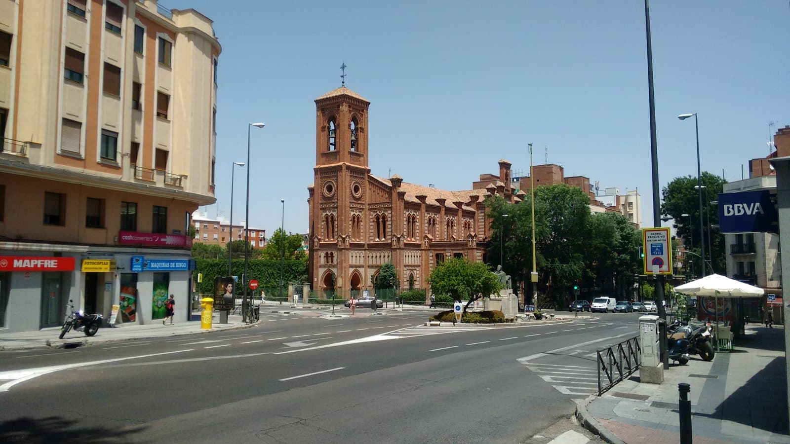 Traffic lanes on Paseo de Extremadura beside a brick church, photographed in 2016.